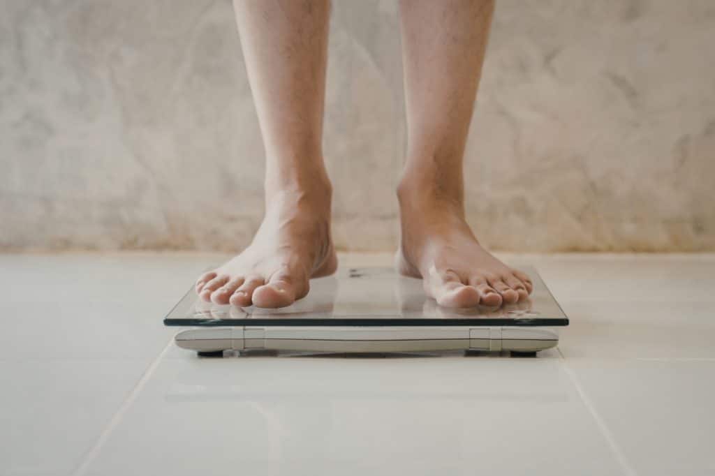 A woman steps on scales as she tries to lose weight